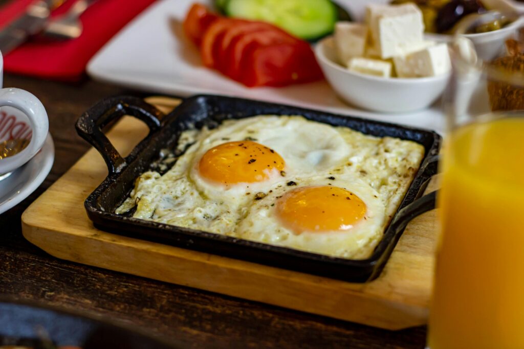 A scrumptious breakfast featuring sunny side up eggs and fresh sides in Cheadle, England.