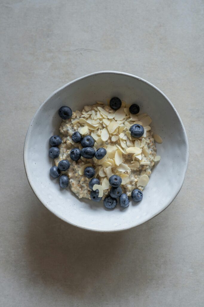 A minimalist bowl filled with oatmeal, fresh blueberries, and almond slices for a healthy breakfast.